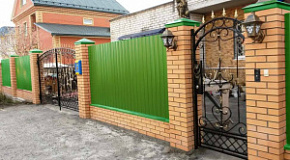 Профлист с ковкой на кирпичных столбах
